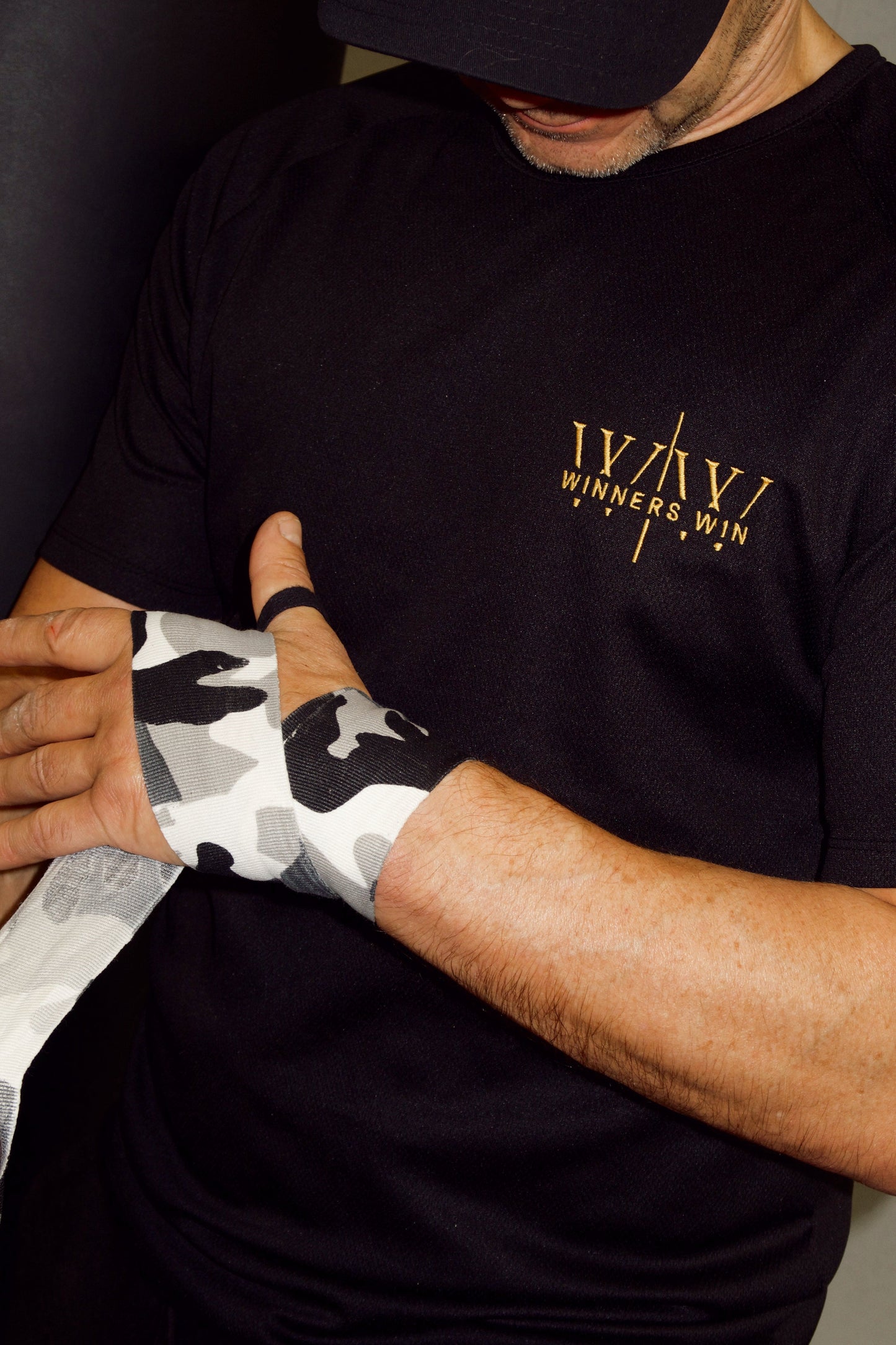 Professional boxer wrapping his hands wearing the Winners Win performance gym t-shirt