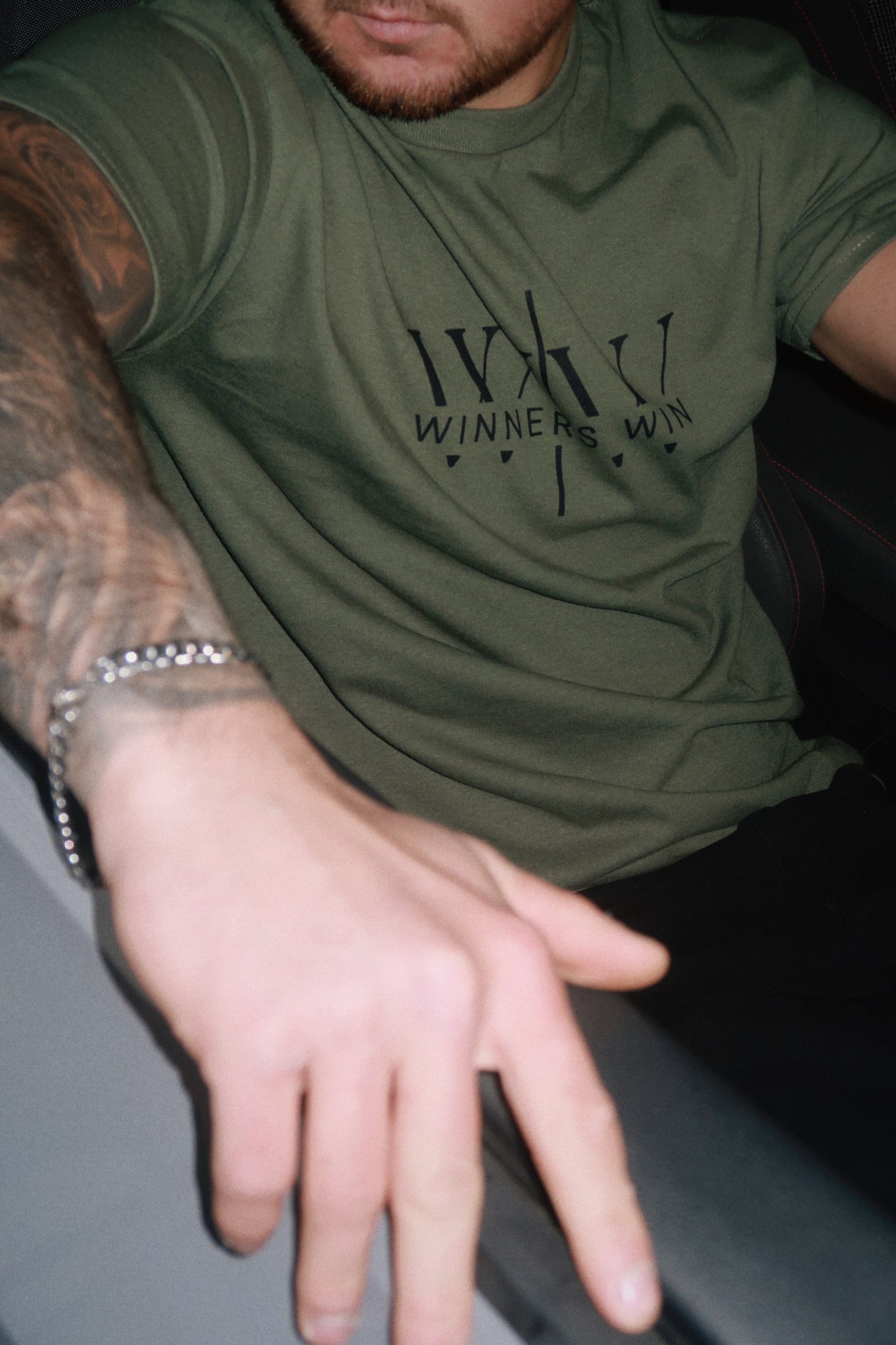 A model in his 2021 Golf GTI wearing the Winners Win core t-shirt in khaki