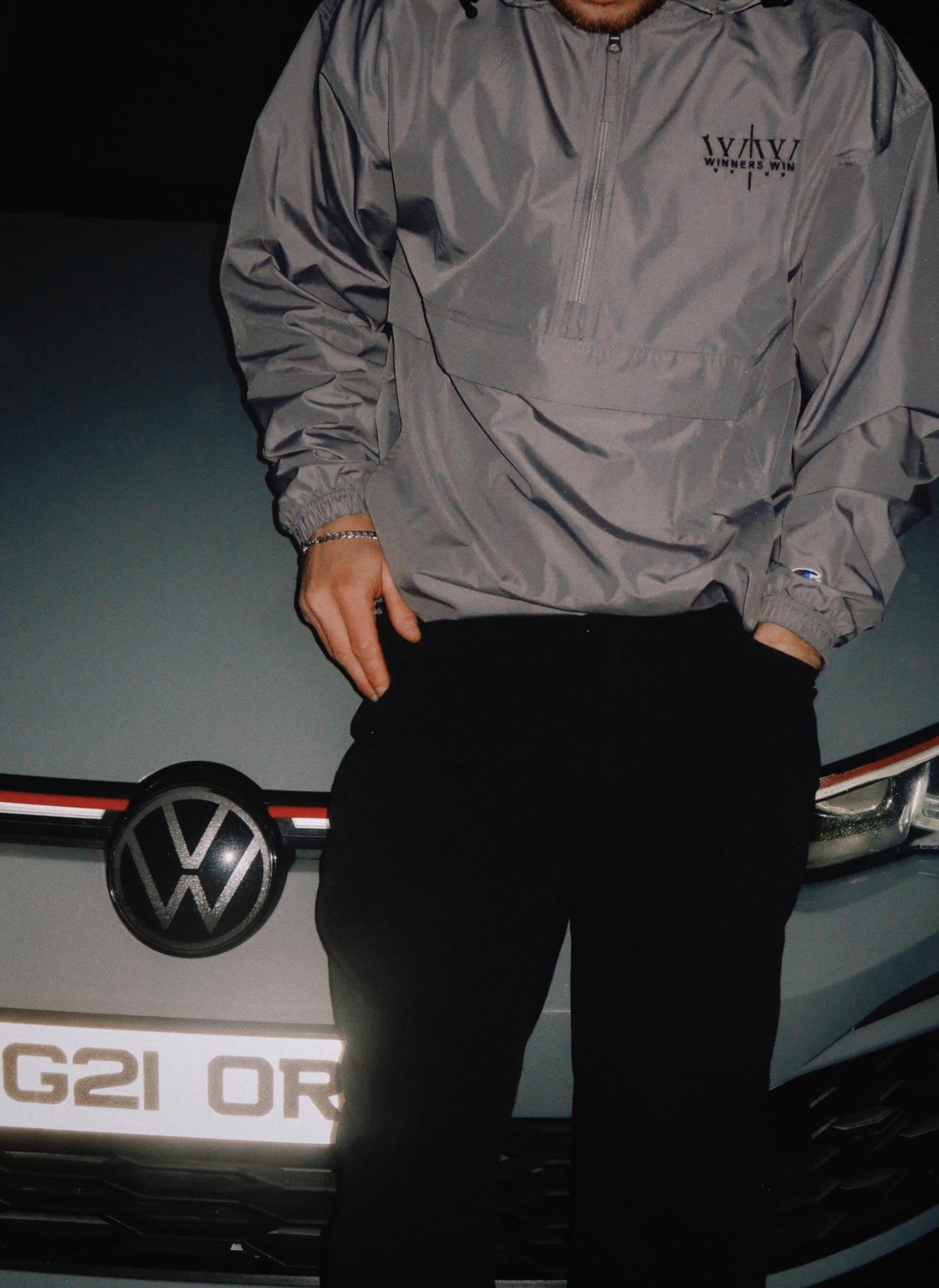 Grey Winners Win waterproof jacket beside a Golf GTI