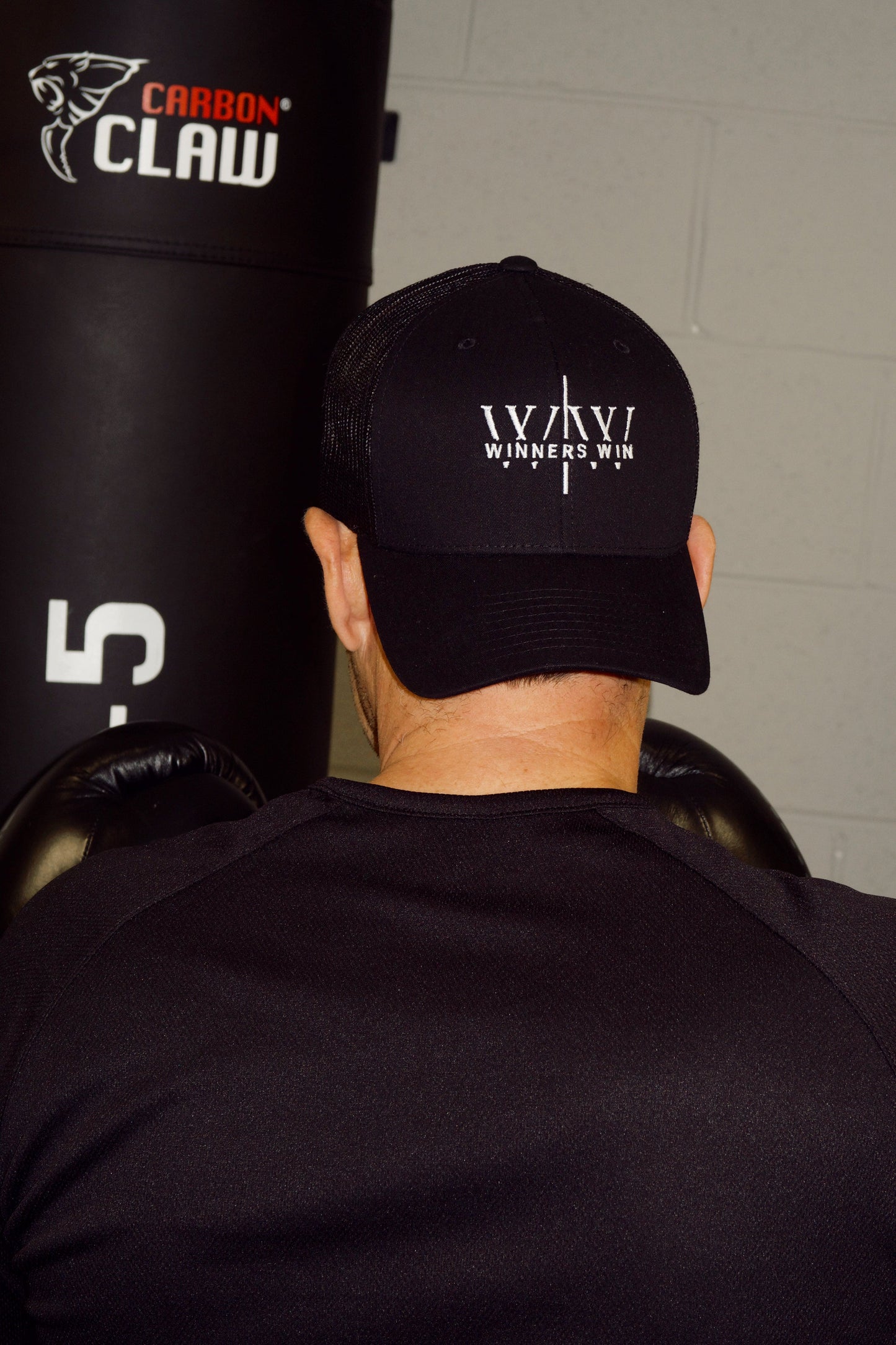 boxer wearing the winners win black and white cap while having a hard training session