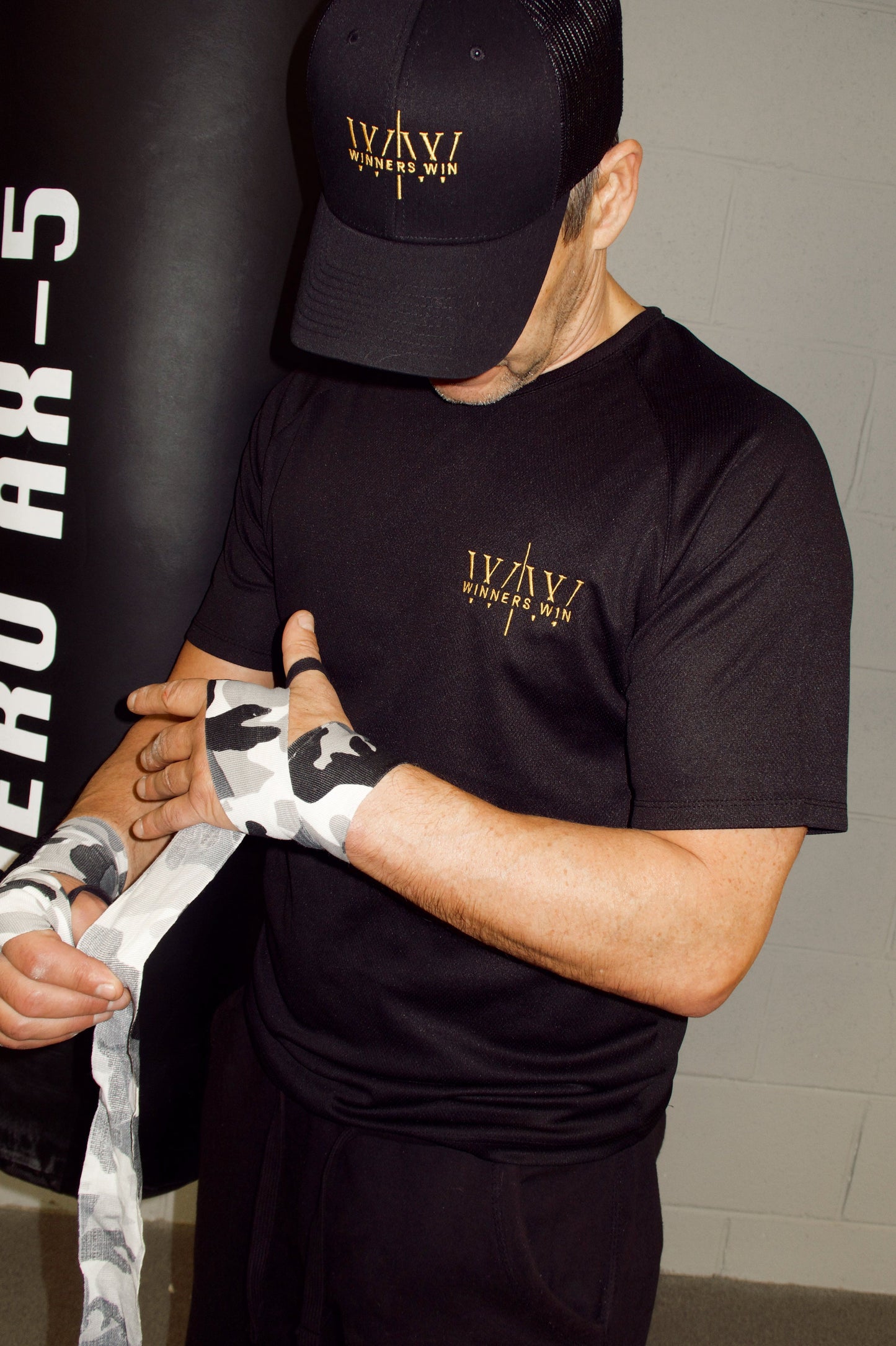 Winners Win black hat being wore by a boxer while putting his hand wraps on